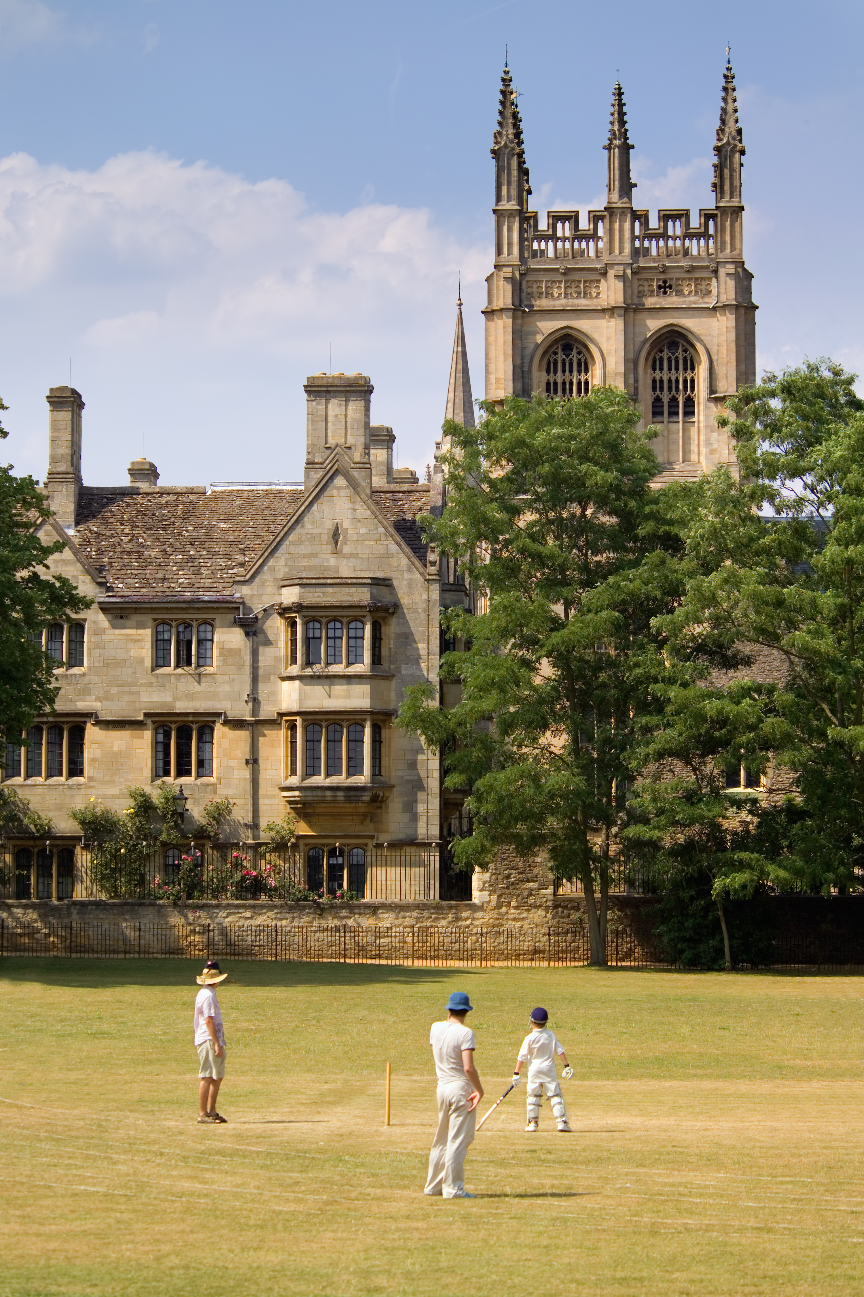 Studerende spiller cricket på Oxford Universitets college med historisk arkitektur