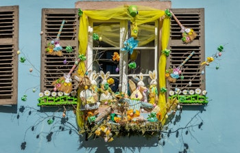 Farverig påskeudstilling med kaniner og æg i vinduet på et historisk hus i Kaysersberg, Alsace, Frankrig