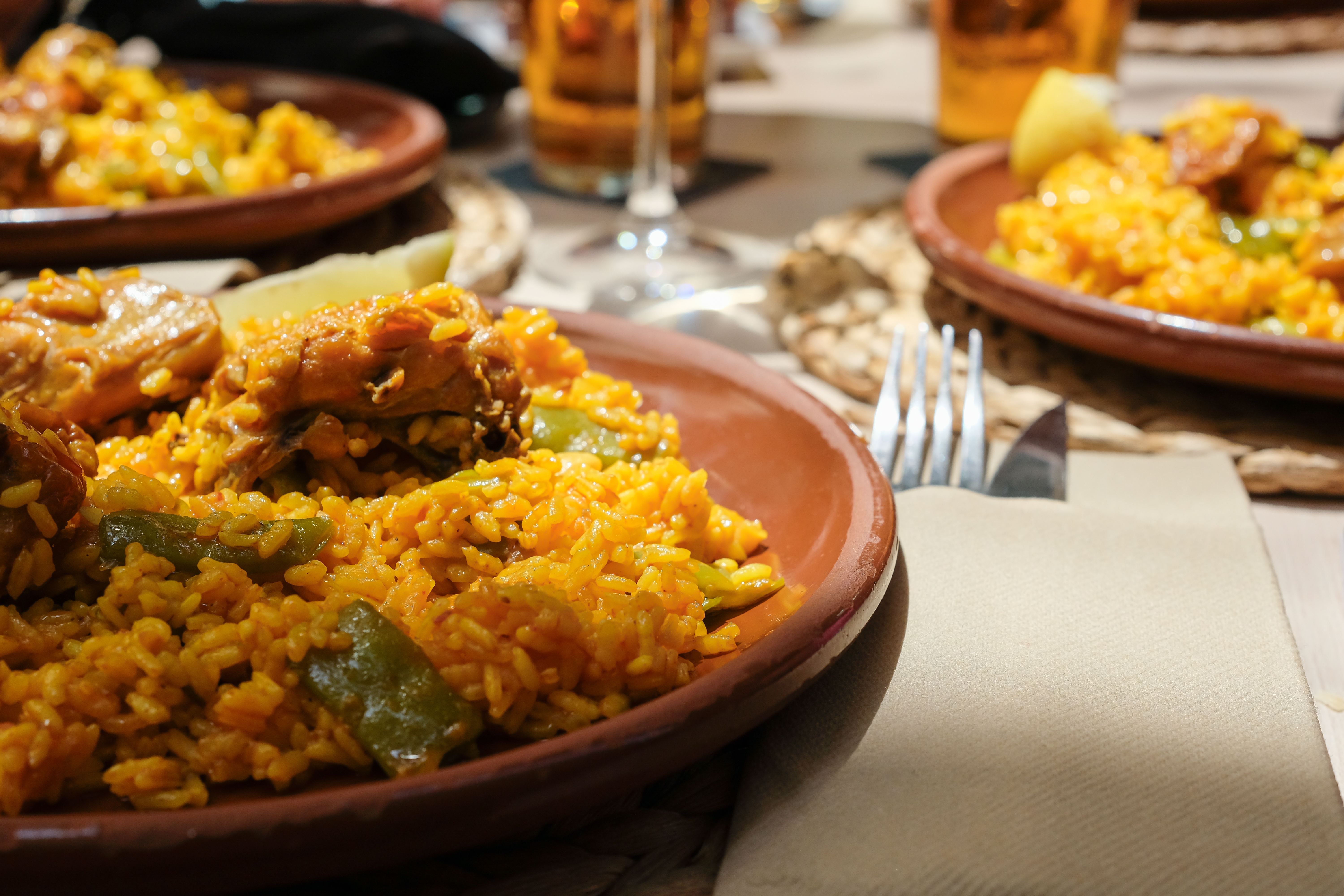 Traditionel Paella Valenciana med kanin, kylling, hvide bønner og artiskok serveret i en hyggelig gaderestaurant i Valencia - en ikonisk spansk specialitet