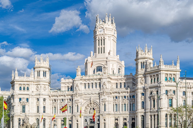 Det historiske Palacio de Cibeles i Madrid, Spanien, en imponerende hvid bygning med dekorative tårne der fungerer som Madrids rådhus