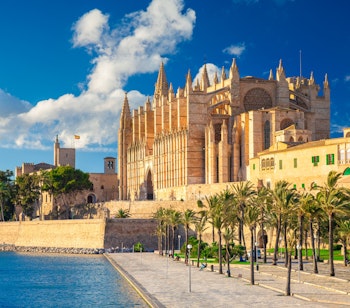 Den gotiske La Seu-katedral spejler sig majestætisk i Middelhavets blå vand ved Parc del Mar i Palma, Mallorca