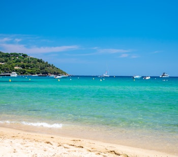 Idyllisk hvid sandstrand ved Pampelonne nær Saint-Tropez med krystalklart turkisblåt vand, perfekt til en luksuriøs sommerferie på den franske riviera