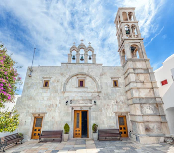 Det historiske Panagia Tourliani kloster i Ano Mera på Mykonos med den karakteristiske hvide facade, dekorative klokketårn og traditionelle kykladiske arkitektur