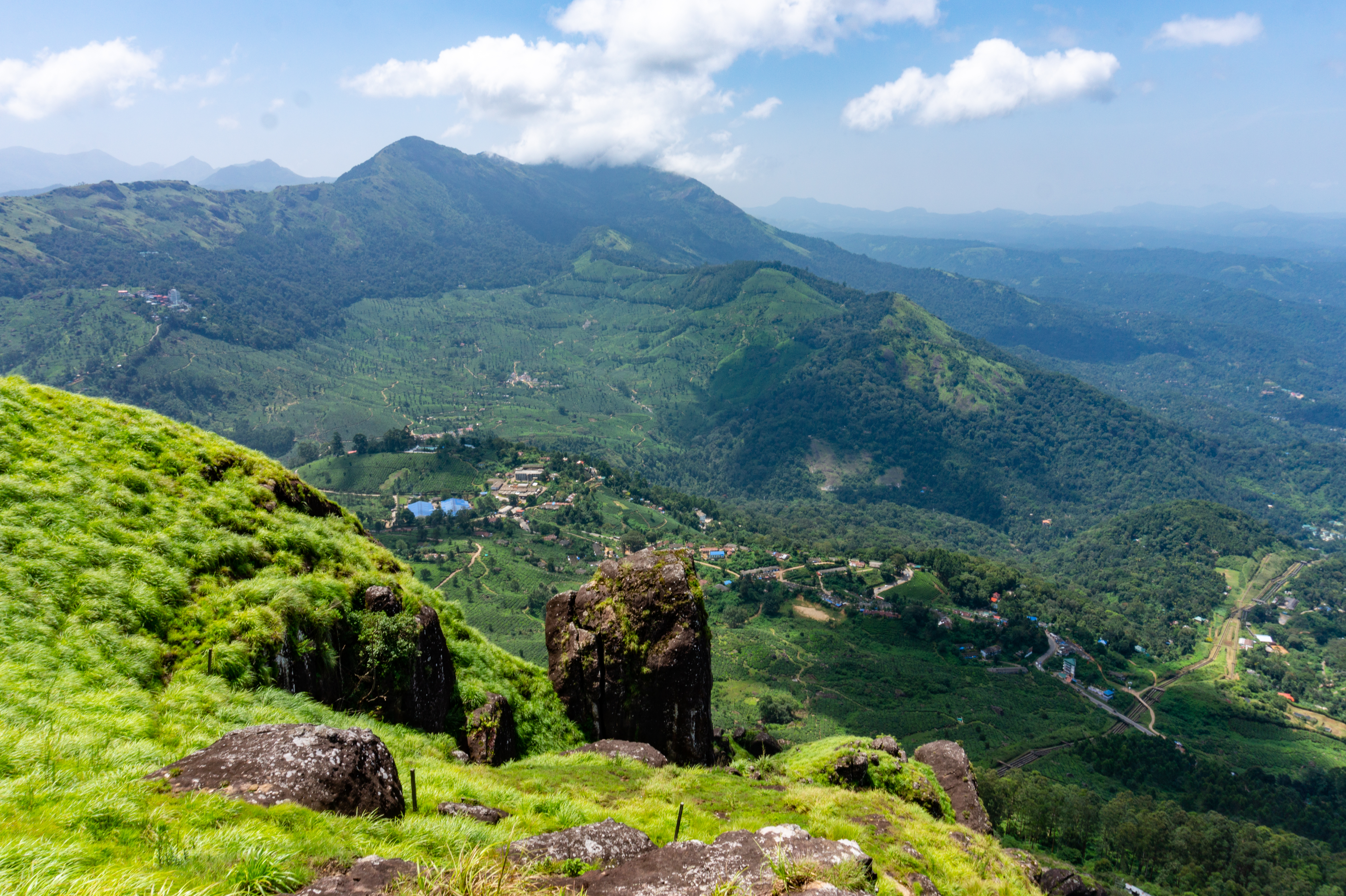 Betagende panoramaudsigt over de grønne bjerge i Western Ghats, Kerala med frodige græssletter og små landsbyer