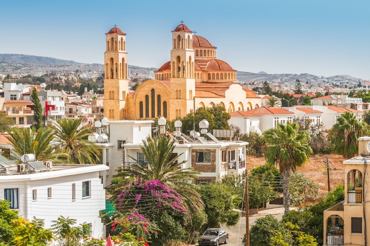 Panoramaudsigt over Paphos i Cypern med historiske bygninger, kirketårne og middelhavsarkitektur under blå himmel