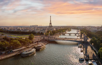 Luftfoto af Paris ved solnedgang med Eiffeltårnet og Seinen