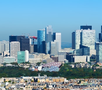 Panoramisk udsigt over La Defense forretningskvarter i Paris med moderne skyskrabere under blå himmel