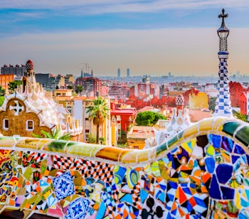 Farverige mosaikbænke i Park Güell, Barcelona, med Antoni Gaudís unikke modernistiske arkitektur og kunstneriske design