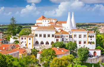 Det farverige Pena-slot troner på bjergtop i Sintra, Portugal med panoramaudsigt over den historiske by og det omkringliggende landskab