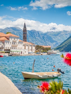 Idyllisk panoramaudsigt over den historiske by Perast ved Kotor-bugten med blomstrende blomster på en solrig sommerdag i Montenegro