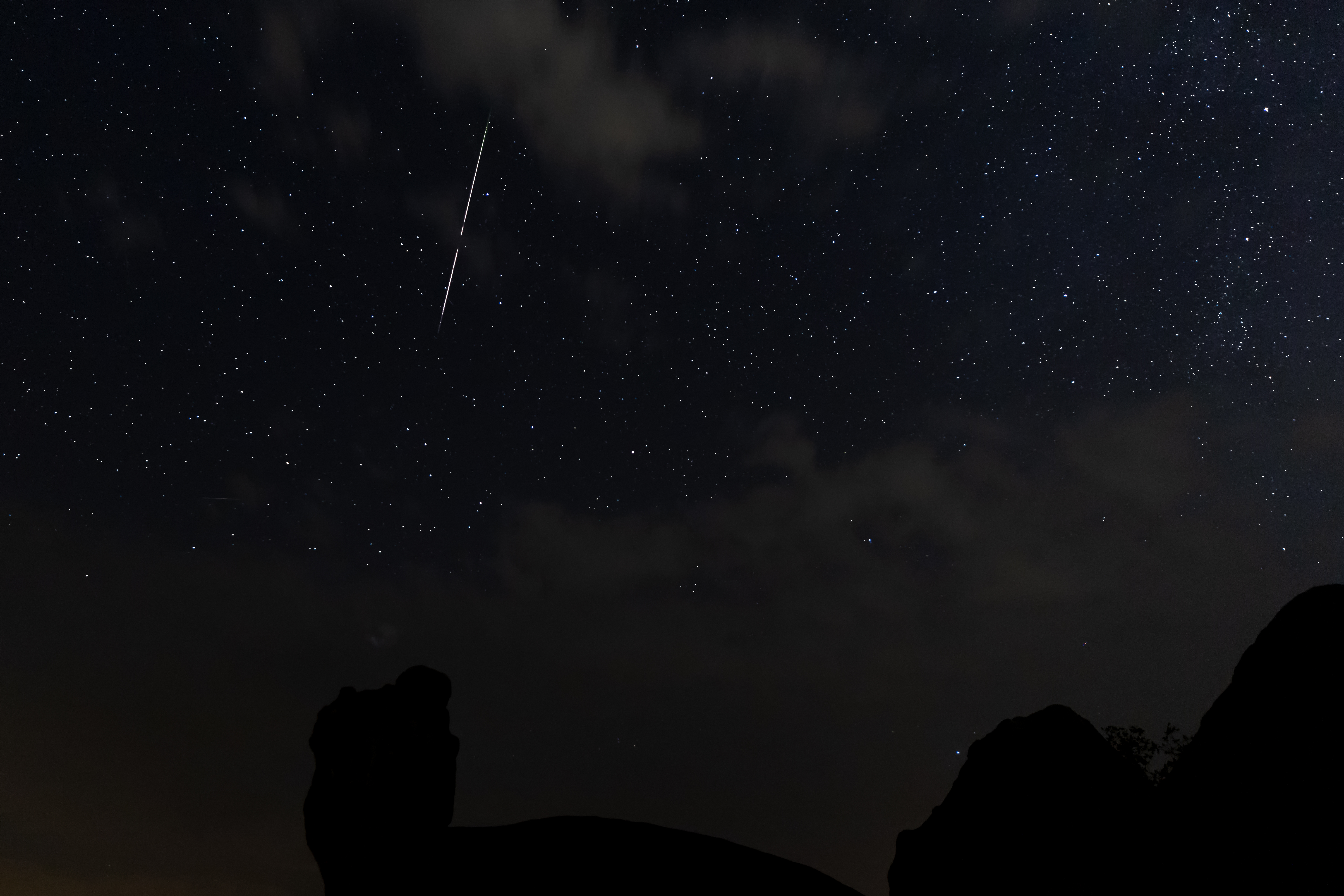 Spektakulær perseid meteorsværm over klippelandskab i Extremadura Spanien med stjerneklar nattehimmel
