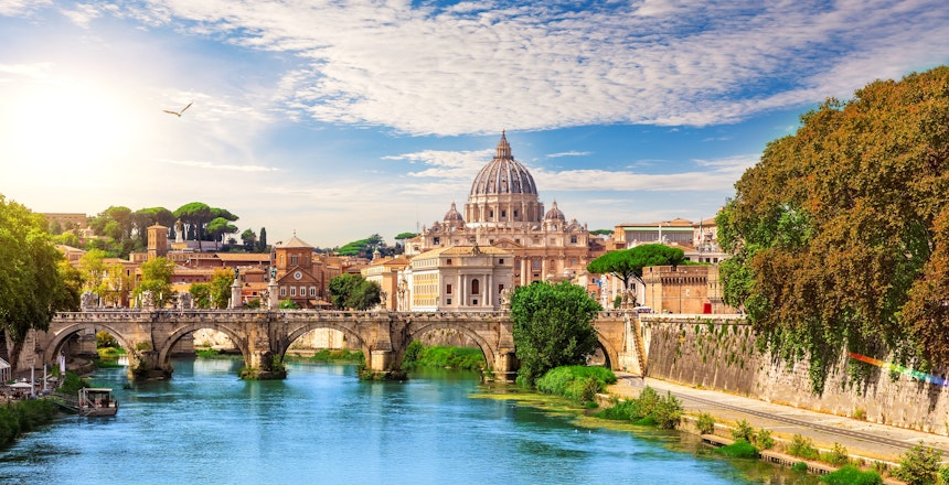 Peterskirken og Aelius-broen over Tiberen i Rom, Italien, med historisk arkitektur og byens silhuet ved solnedgang