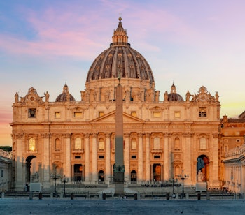 Peterskirken badet i gyldent morgenlys på Peterspladsen i Vatikanet, Roms mest berømte religiøse vartegn med den imponerende kuppel og søjlegang