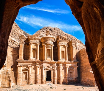 Betagende udsigt til Ad Deir klosteret i Petra, Jordan, set gennem en huleåbning i dette UNESCO verdensarvssted