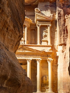 Skatkammeret i Petra set gennem den smalle Siq-kløft med gyldne sandstensklipper, der indrammer det antikke nabatæiske monument i Jordan