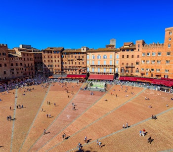 Luftfoto af den berømte muslingeformede Piazza del Campo i Siena, Toscana, med historiske bygninger og hyggelige terrassecafeer