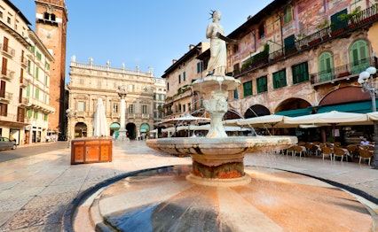 Det smukke historiske torv Piazza delle Erbe i Verona med fontæner og monumenter badet i det gyldne morgenlys
