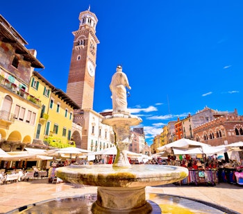 Den historiske Piazza delle Erbe i Verona med det livlige marked og det ikoniske Torre Lamberti tårn i Italiens Veneto-region