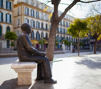 Ikonisk bronzestatue af Pablo Picasso siddende på en bænk på Plaza de la Merced i Malaga, kunstnerens fødeby i Andalusien