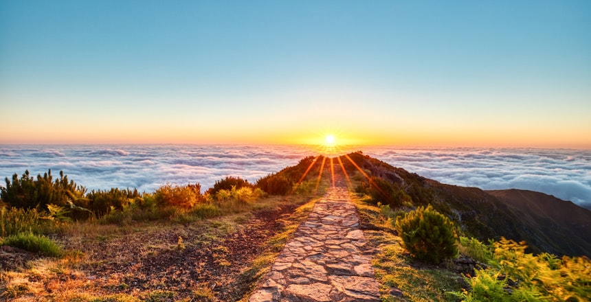 Betagende solopgang set fra Pico Ruivo, Madeiras højeste bjergpunkt med dramatiske skyer og farverig morgenhimmel over det portugisiske ølandskab