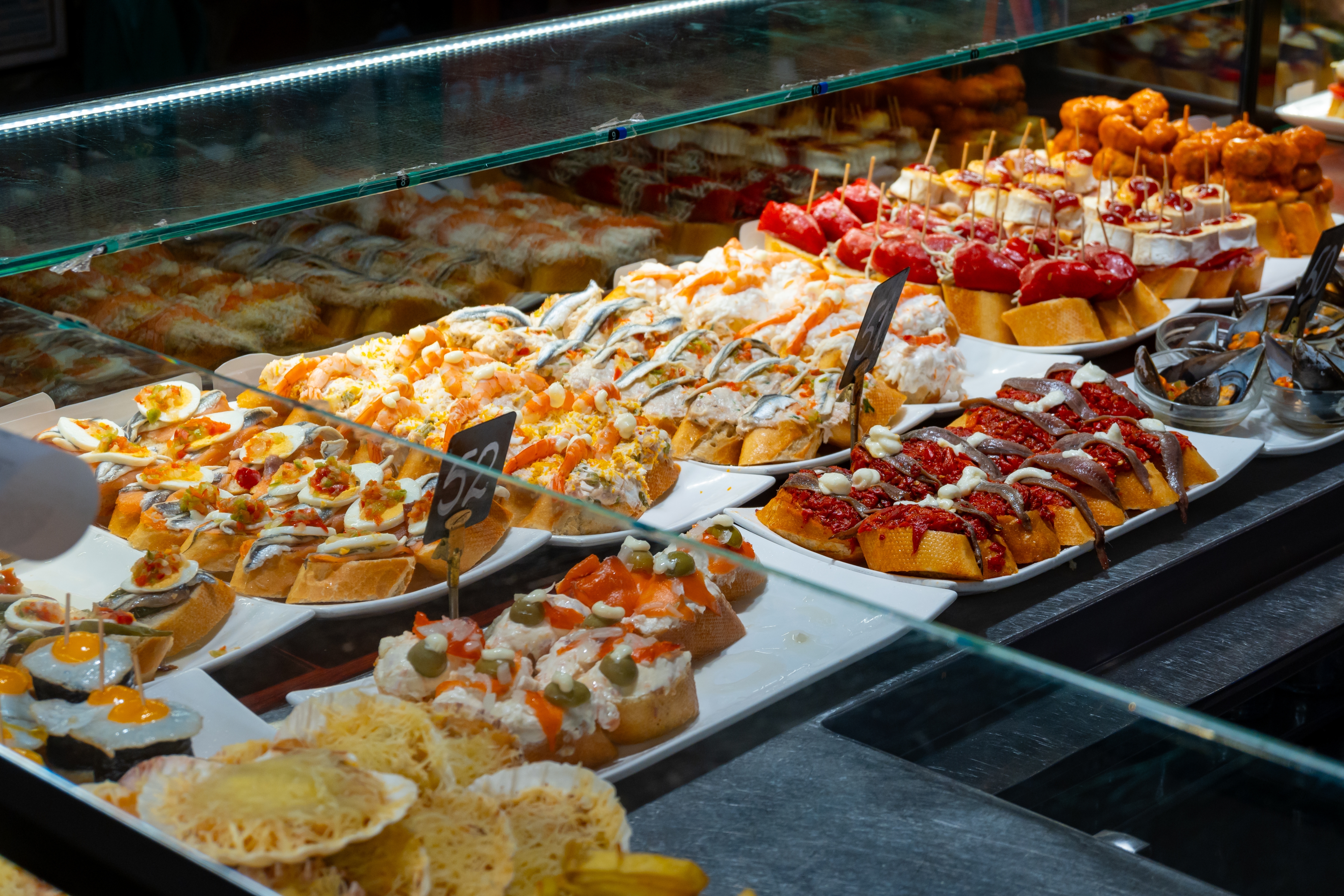 Traditionelle baskiske pintxos i en bar i San Sebastian med et lækkert udvalg af seafood, ansjoser og gedeost på ristet brød