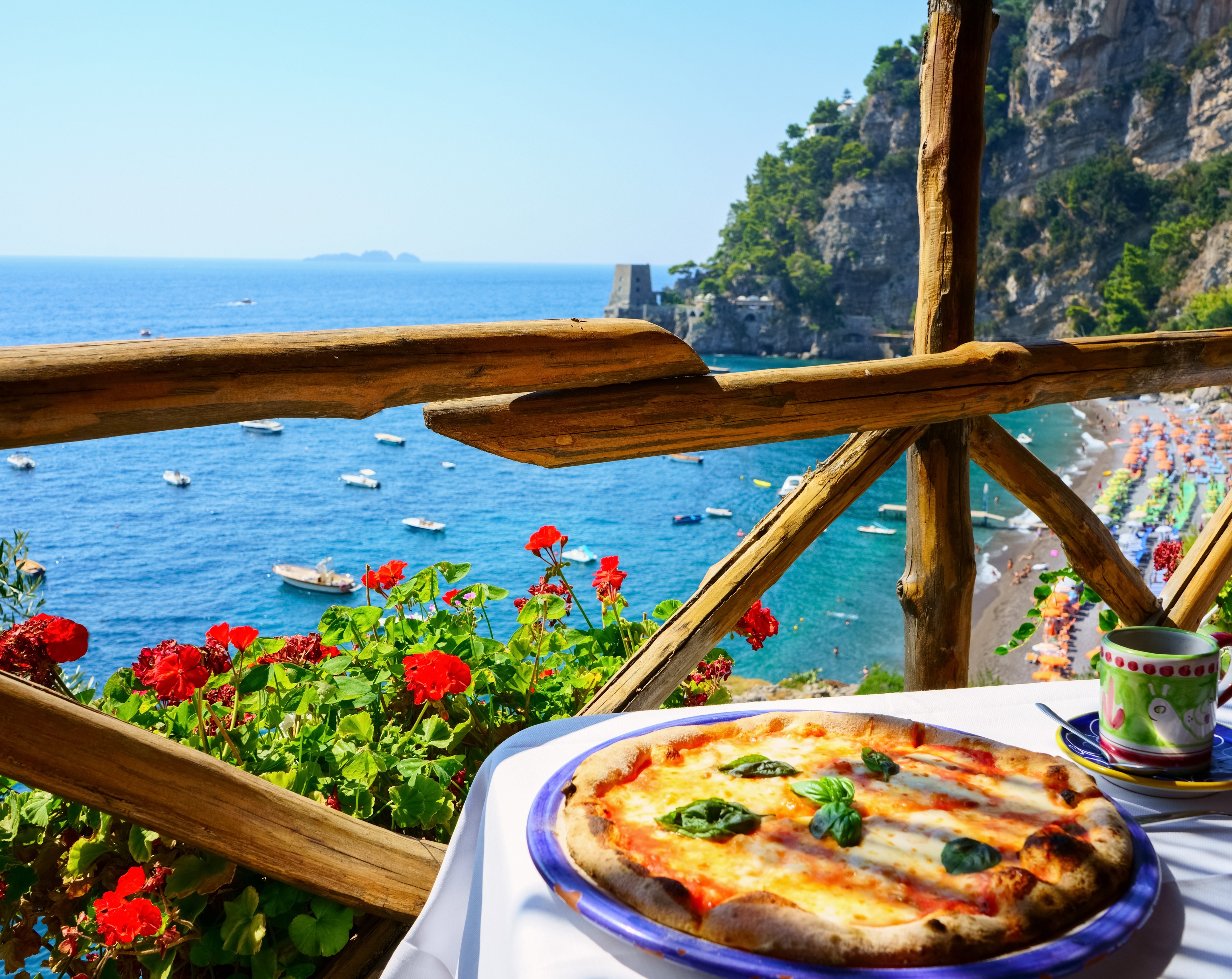 Pizza serveret på træterrasse med spektakulær udsigt over Amalfi-kysten og Middelhavet