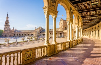 Den imponerende Plaza de España i Sevilla med sin karakteristiske halvmåneformede bygning, dekorative broer og kanaler - et berømt landemærke fra 1928, der viser renæssance- og maurisk arkitektur i Andalusien