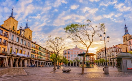 Det historiske Plaza Mayor torv i Segovia med katedralen, rådhuset og teatret badet i solnedgangens gyldne lys