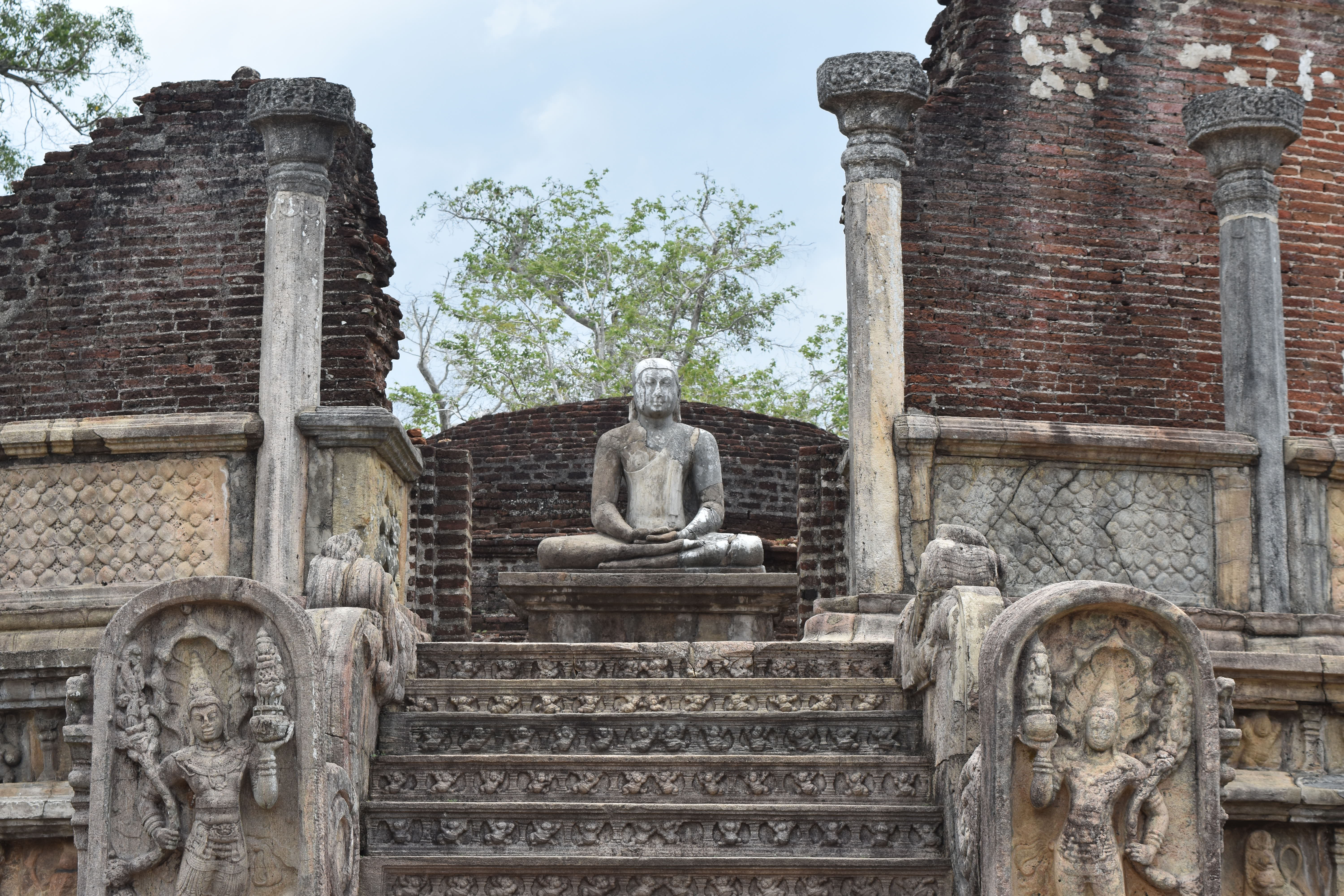 Buddha-statue ved det historiske Vatadageya tempel i Polonnaruwa, Sri Lanka med udsmykkede stentrapper og ældgammel arkitektur
