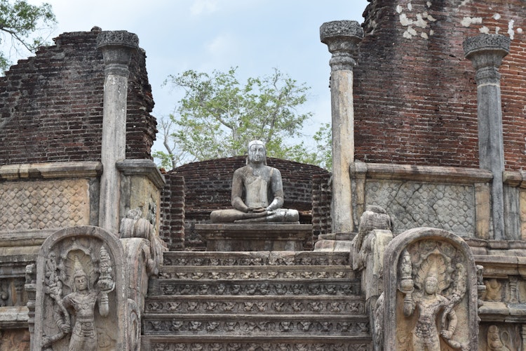 Buddha-statue ved det historiske Vatadageya tempel i Polonnaruwa, Sri Lanka med udsmykkede stentrapper og ældgammel arkitektur
