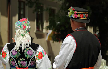 Traditionelle polske folkedansere i farverige broderede dragter under kulturfestival i Polen