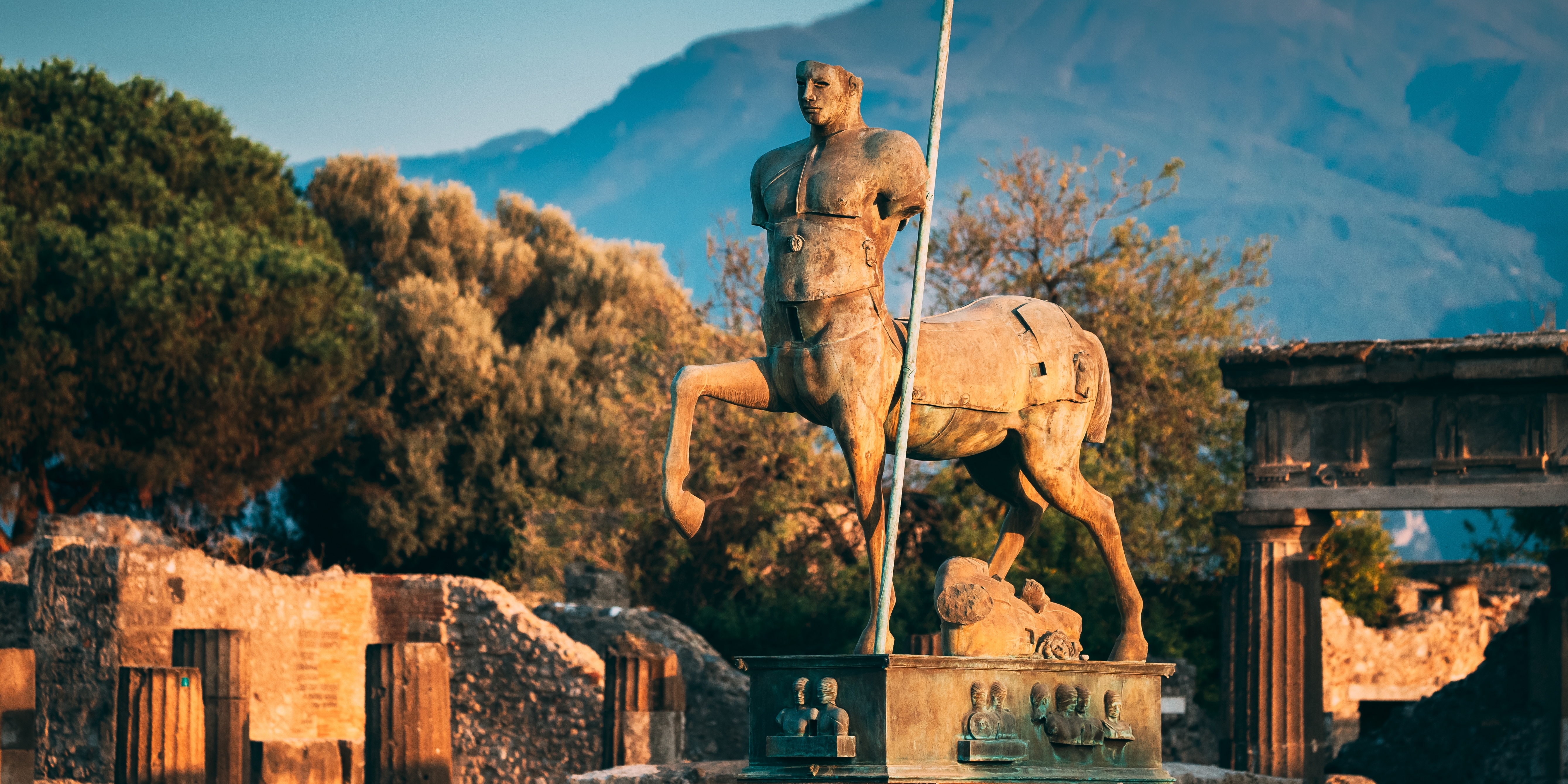 Antik centaur statue i Pompeii med historiske ruiner og Vesuvius i baggrunden