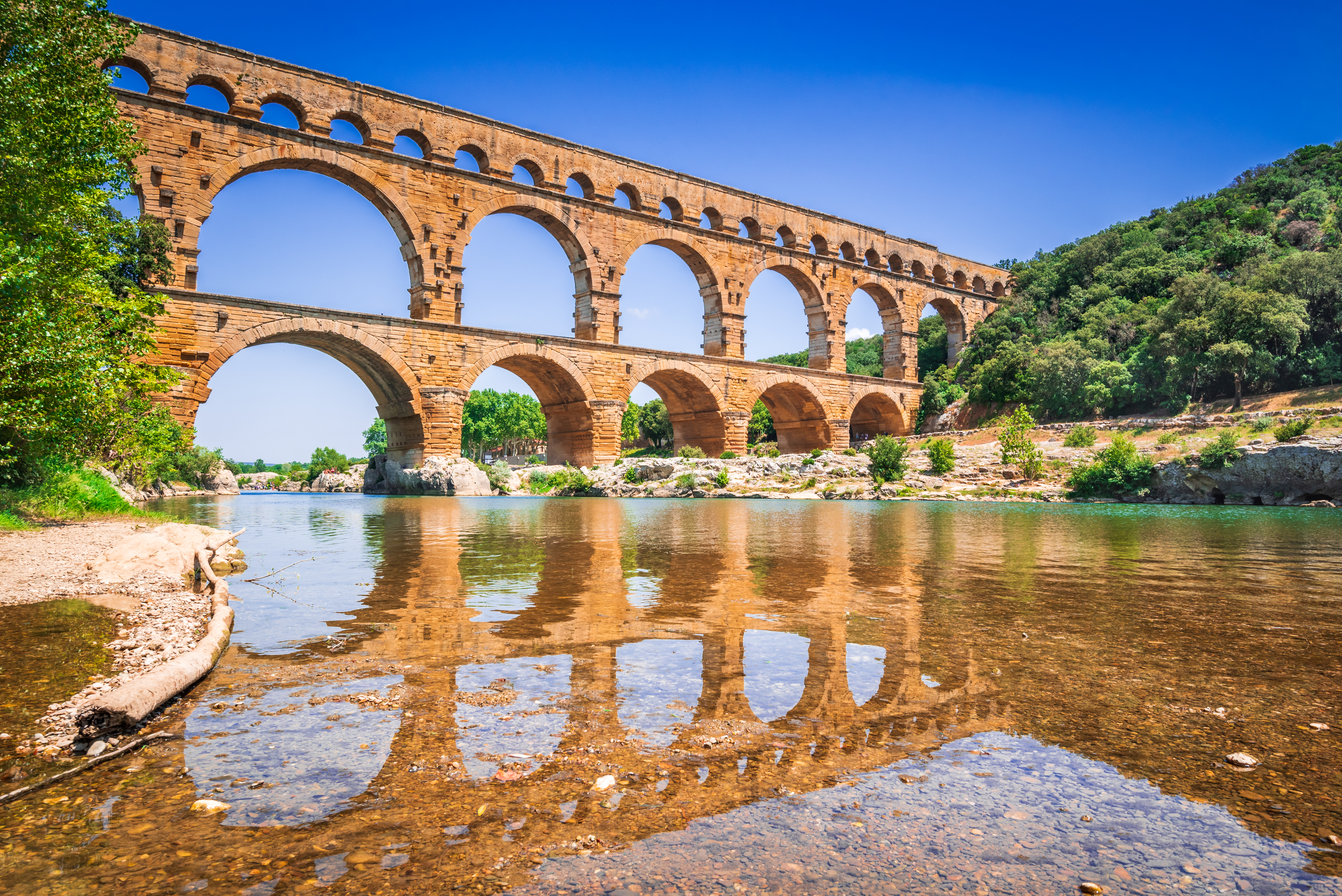 Den berømte Pont du Gard romerske akvadukt bro spejler sig i Gardon-floden i det sydlige Frankrig