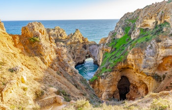 Gyldenbrune kalkstensklipper og turkisblåt vand ved Ponta da Piedade nær Lagos i Algarve, Portugal - et højdepunkt på vandreferie langs Algarvekysten