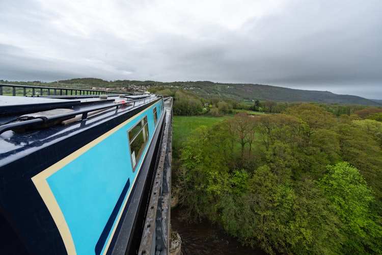 Historisk Pontcysyllte Aqueduct bro i Wales med kanalbåd over grønt landskab