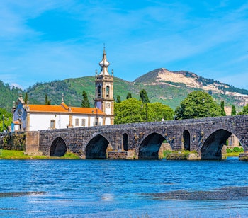 Den historiske romerske bro med stenbuer over floden Lima i den charmerende middelalderlandsby Ponte de Lima, Portugal