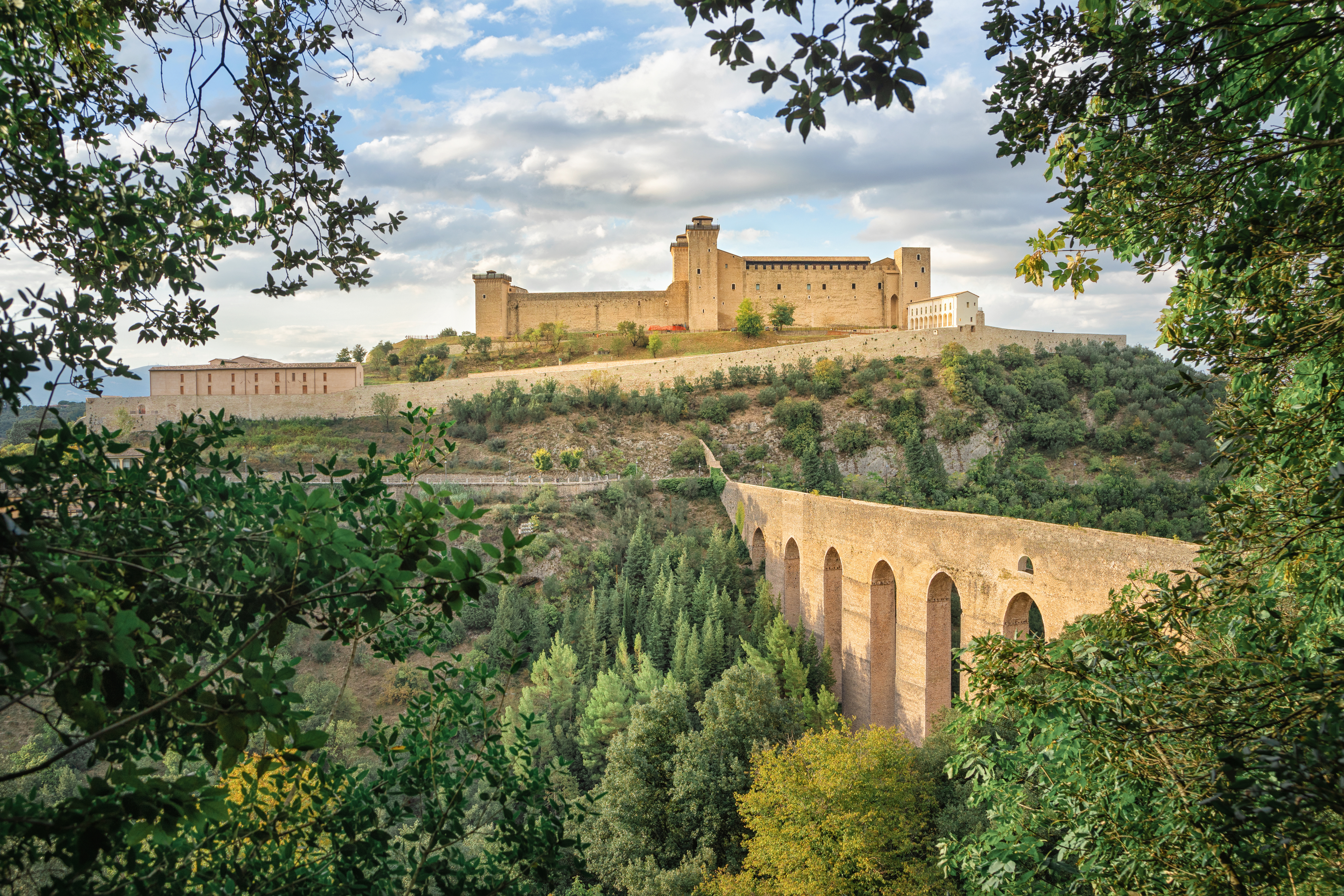 Den historiske Ponte delle Torri middelalderbro og Rocca Albornoziana fæstningen på bakketoppen i Spoleto, en smuk destination på vores elcykelrejse gennem hjertet af Italien