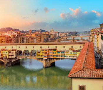 Den historiske Ponte Vecchio bro med farverige butikker over Arno-floden i Firenze, Toscana - et ikonisk renæssance-landemærke i Italien