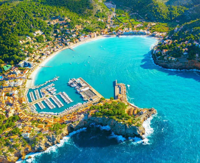 Betagende panoramaudsigt over Port de Sollers azurblå bugt med lystbådehavn og den charmerende kystby omgivet af frodige bjerge på Mallorca