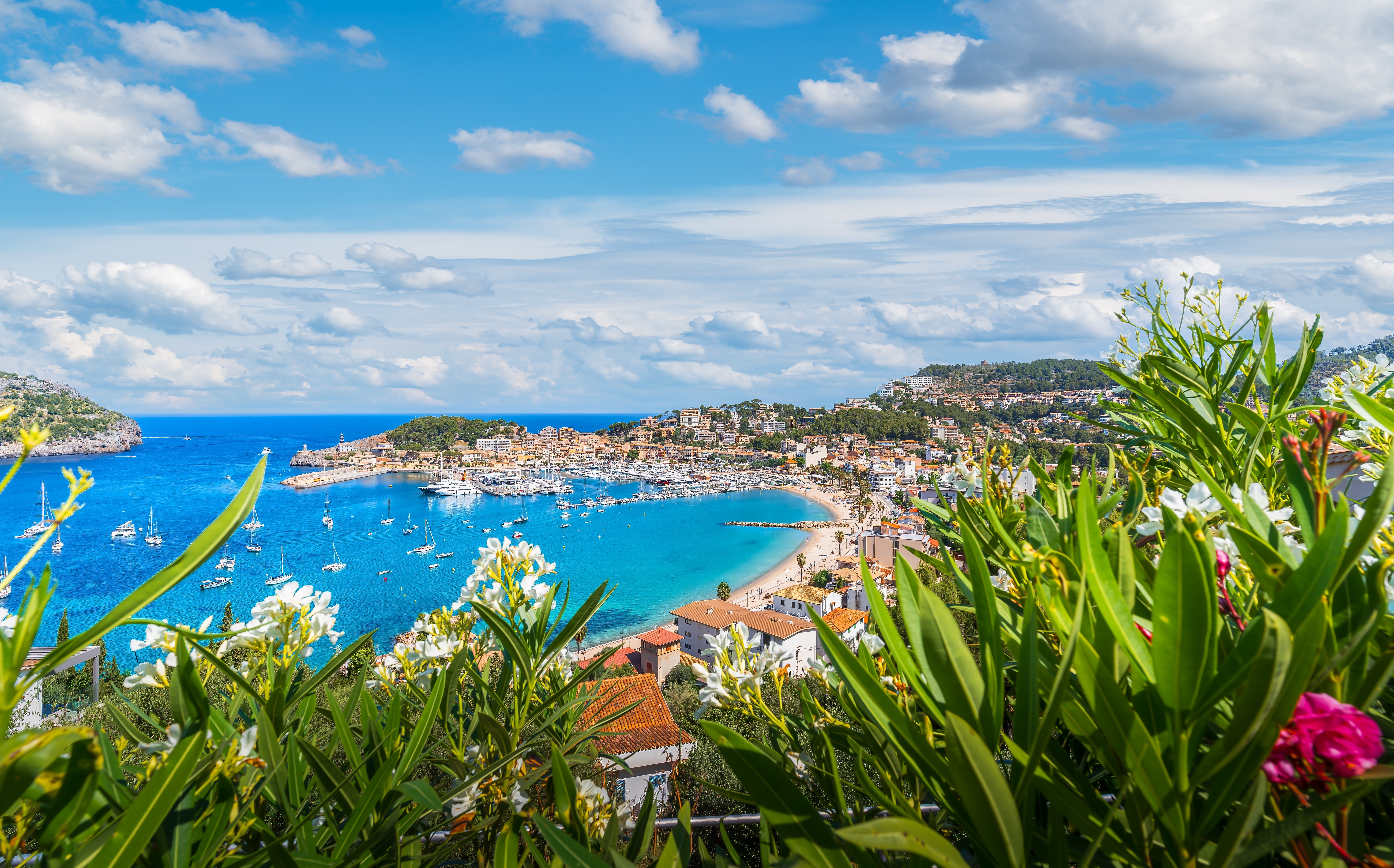 Luftfoto af Port de Soller på Mallorca med azurblåt Middelhav omgivet af UNESCO-beskyttede Tramuntana-bjerge og hyggelig marina med lystbåde
