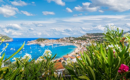 Luftfoto af Port de Soller på Mallorca med azurblåt Middelhav omgivet af UNESCO-beskyttede Tramuntana-bjerge og hyggelig marina med lystbåde