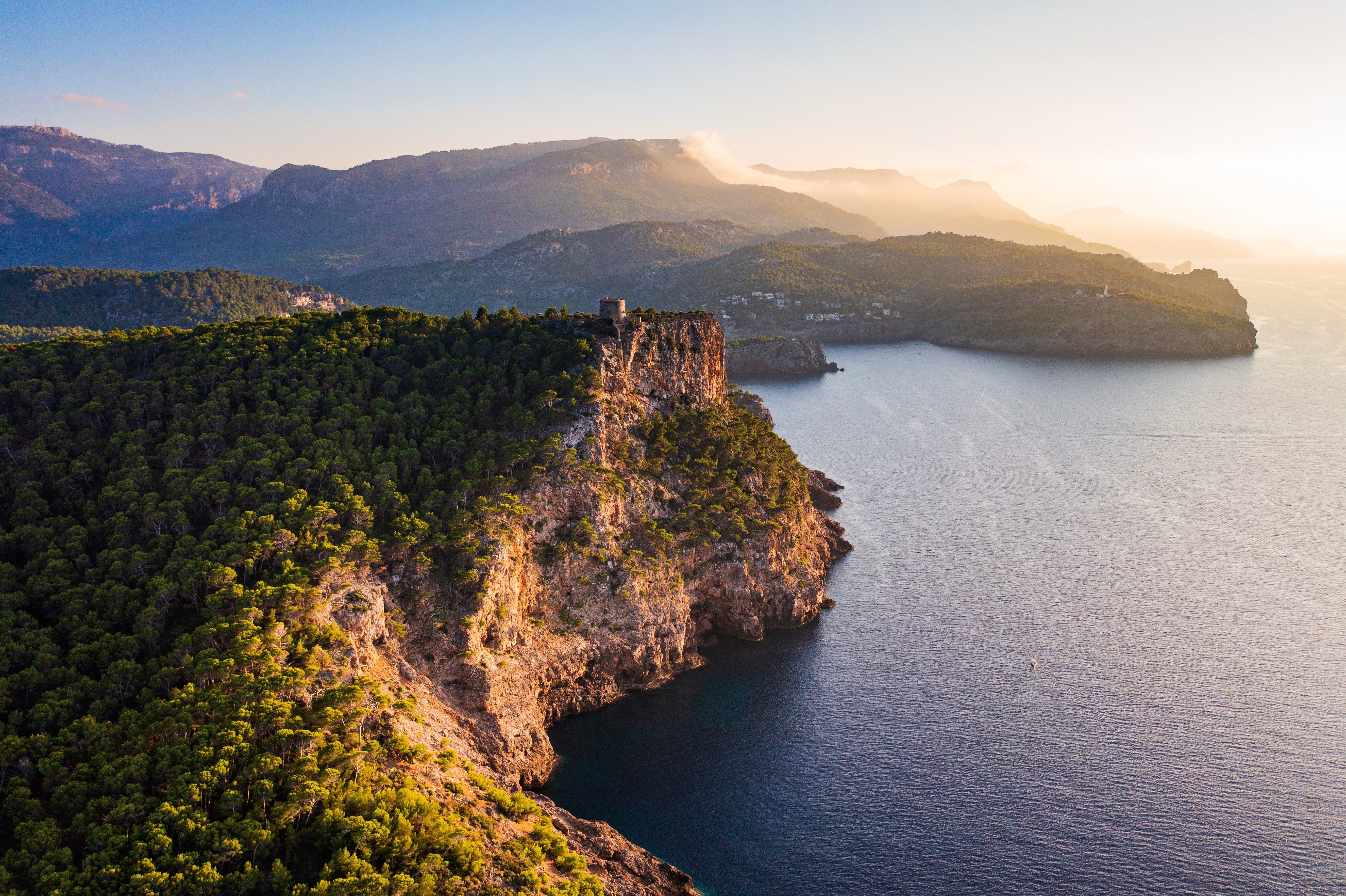 Luftfoto af det historiske Torre Picada vagttårn beliggende på de dramatiske klipper med udsigt over det dybe blå Middelhav langs Port de Sollers kystlinje på Mallorca