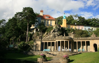 Imponerende kolonnade i den historiske Portmeirion landsby i Nordwales, designet af Clough Ellis-Williams, omgivet af frodige haver og unik arkitektur