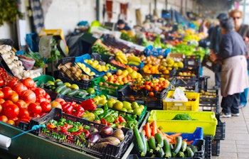 Farverige boder med friske grøntsager og frugt på det traditionelle Bolhao marked i Porto, Portugal med lokale sælgere