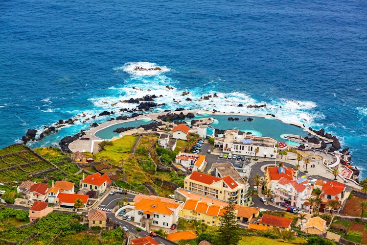 Flot luftfoto af Porto Moniz naturlige lavapools og kystby på Madeira Portugal