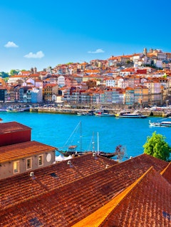 Betagende udsigt over Portos farverige historiske bygninger langs Douro-floden på en solrig sommerdag med den karakteristiske portugisiske bysilhuet