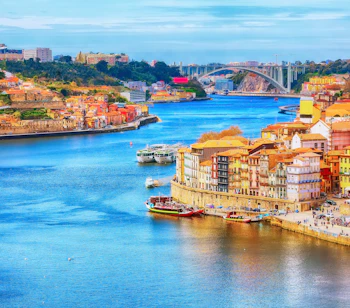 Luftudsigt over Porto's historiske Ribeira-kvarter med farverige huse og både på Douro-floden i Portugal