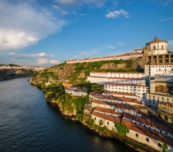 Betagende solnedgang over Douro-floden med udsigt til Mosteiro da Serra do Pilar klosteret i Porto, Portugal