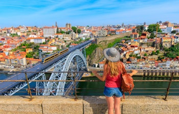 Kvindelig turist nyder panorama udsigt over Porto Portugal med bro over Douro floden