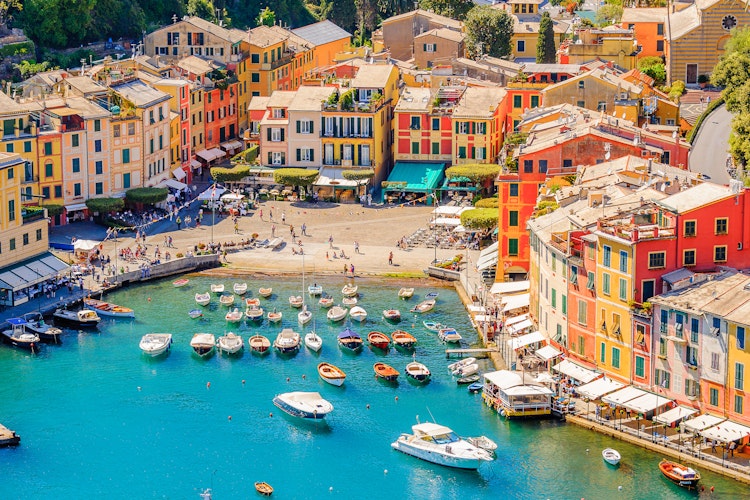 Malerisk udsigt over Portofinos charmerende havn med farverige bygninger og lystbåde ved det azurblå Middelhav, en perle på den italienske riviera i Ligurien